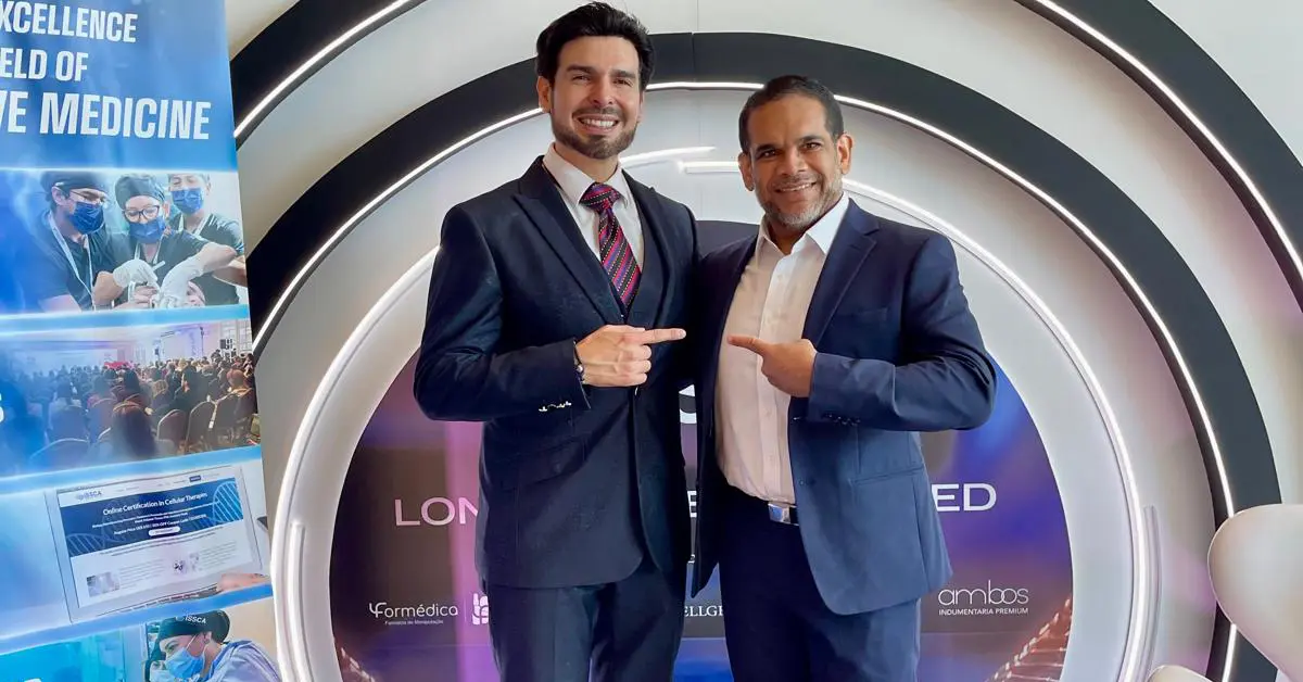 Dr. Christopher Walker standing with a colleague at an ISSCA regenerative medicine event, discussing stem cell therapy and medical training advancements