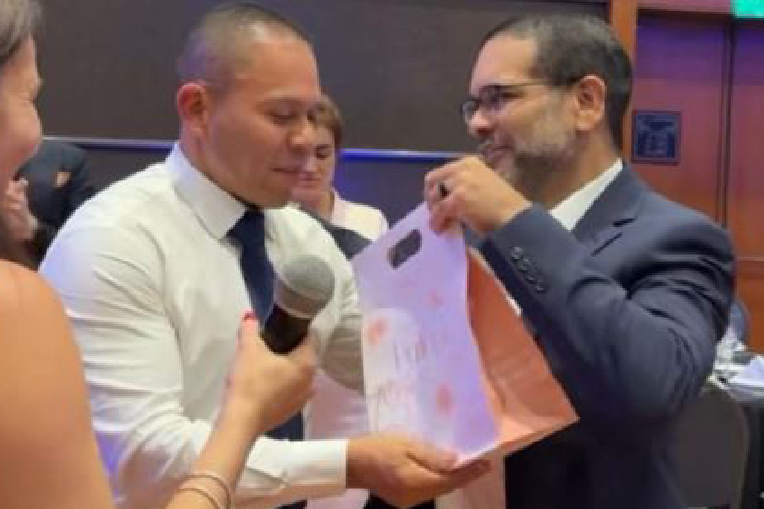 Dr. Christopher Walker presenting a gift token to a participant during regenerative medicine education event & professional medical seminar
